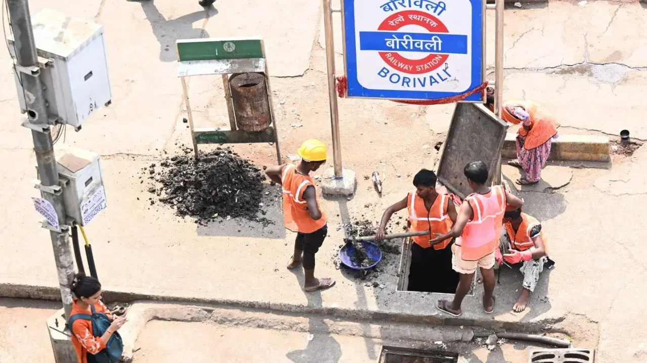 Workers clear soil and plastic waste from drains at Swami Vivekananda Road near Borivali station. FILE PIC