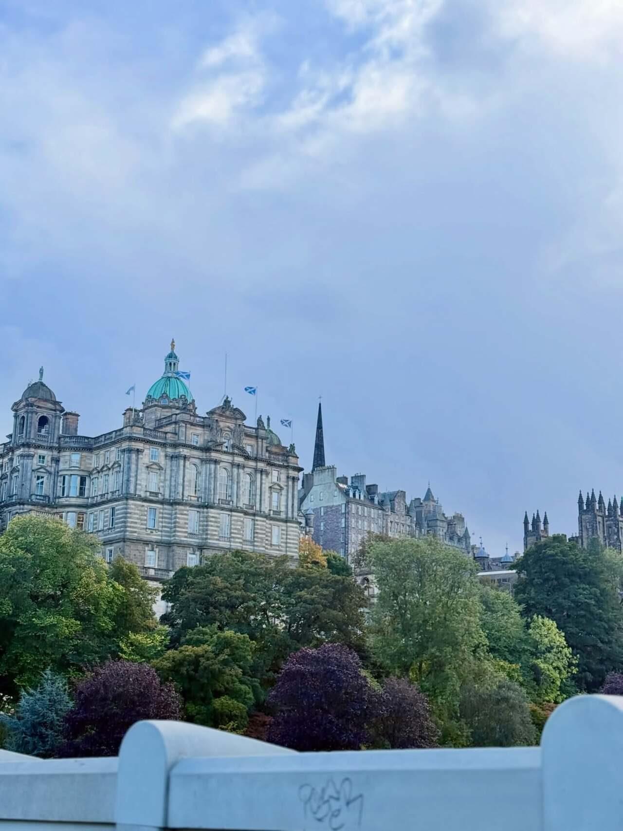 North Bridge offers sweeping views of Edinburgh’s grand architecture, with historic buildings lining the road beneath a clear blue sky