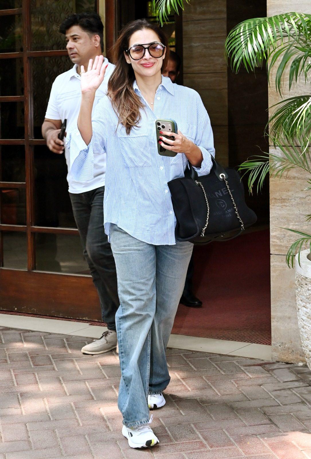 Malaika Arora was seen stepping out in a chic shirt paired with blue jeans and accessorised with a black handbag Malaika Arora was seen stepping out in a chic shirt paired with blue jeans and accessorised with a black handbag