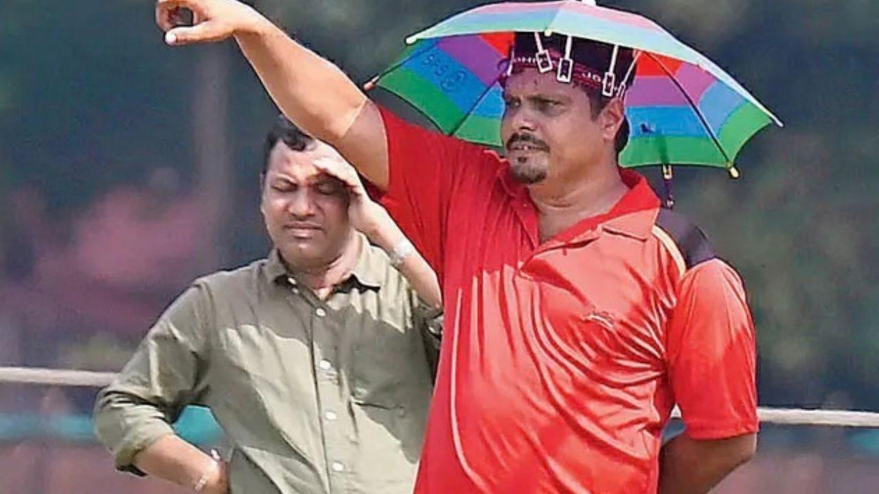 An inter-school competition coach wears an umbrella hat at Azad Maidan- The coach gestures to players while using an umbrella hat for protection from the sun as Mumbai swelters under the post-monsoon heatwave An inter-school competition coach wears an umbrella hat at Azad Maidan- The coach gestures to players while using an umbrella hat for protection from the sun as Mumbai swelters under the post-monsoon heatwave