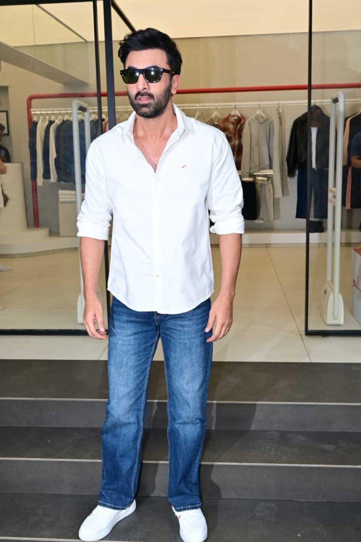 Ranbir Kapoor was recently spotted keeping it effortlessly stylish in a classic white button-down shirt paired with blue jeans and clean white sneakers. Ranbir Kapoor was recently spotted keeping it effortlessly stylish in a classic white button-down shirt paired with blue jeans and clean white sneakers.