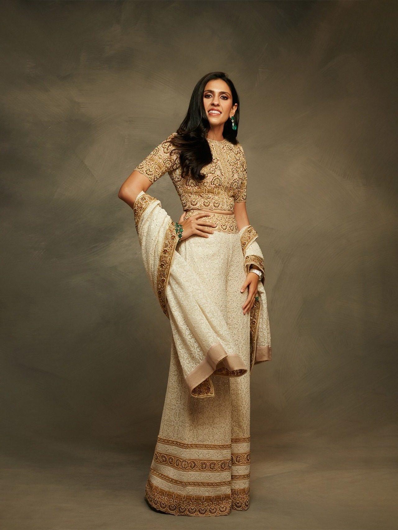 Shloka was seen wearing a regal ivory and gold ensemble featuring a delicately embroidered traditional top paired with a flowing, multi-layered white skirt.