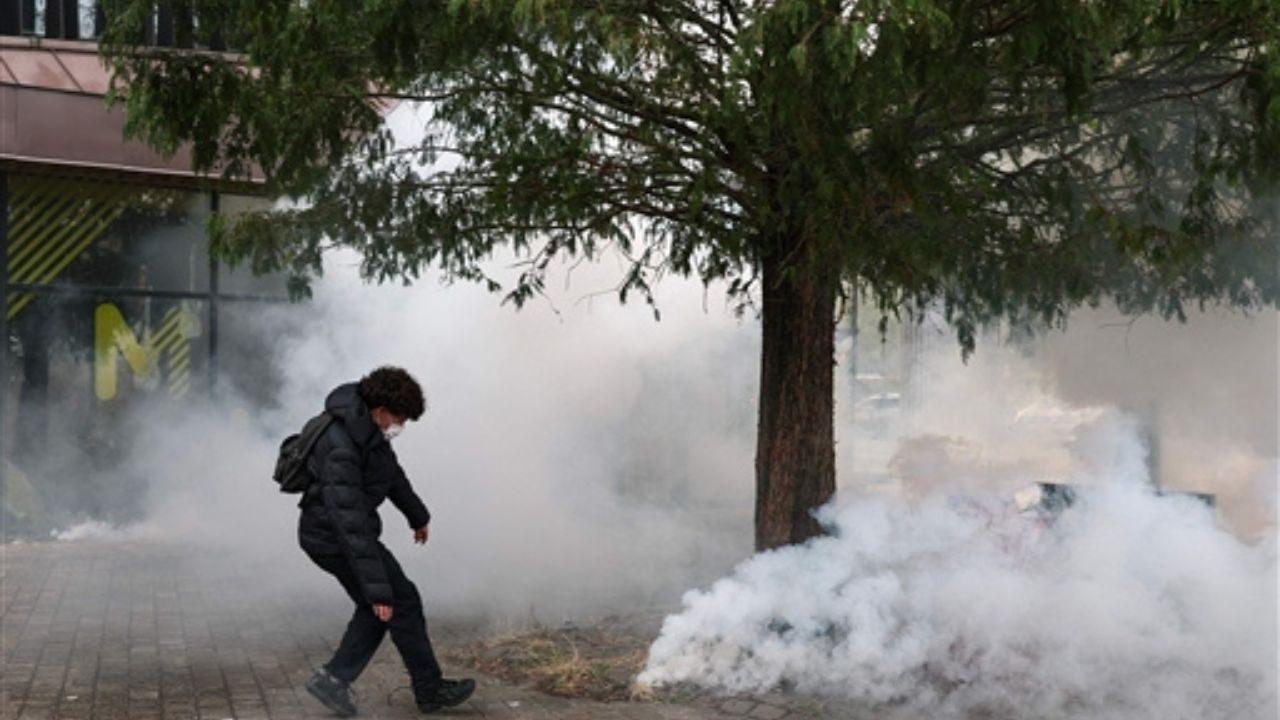 Students take cover from teargas during scuffles with police as they carry out a blocking protest at the Cesar Baggio secondary school, in Lille