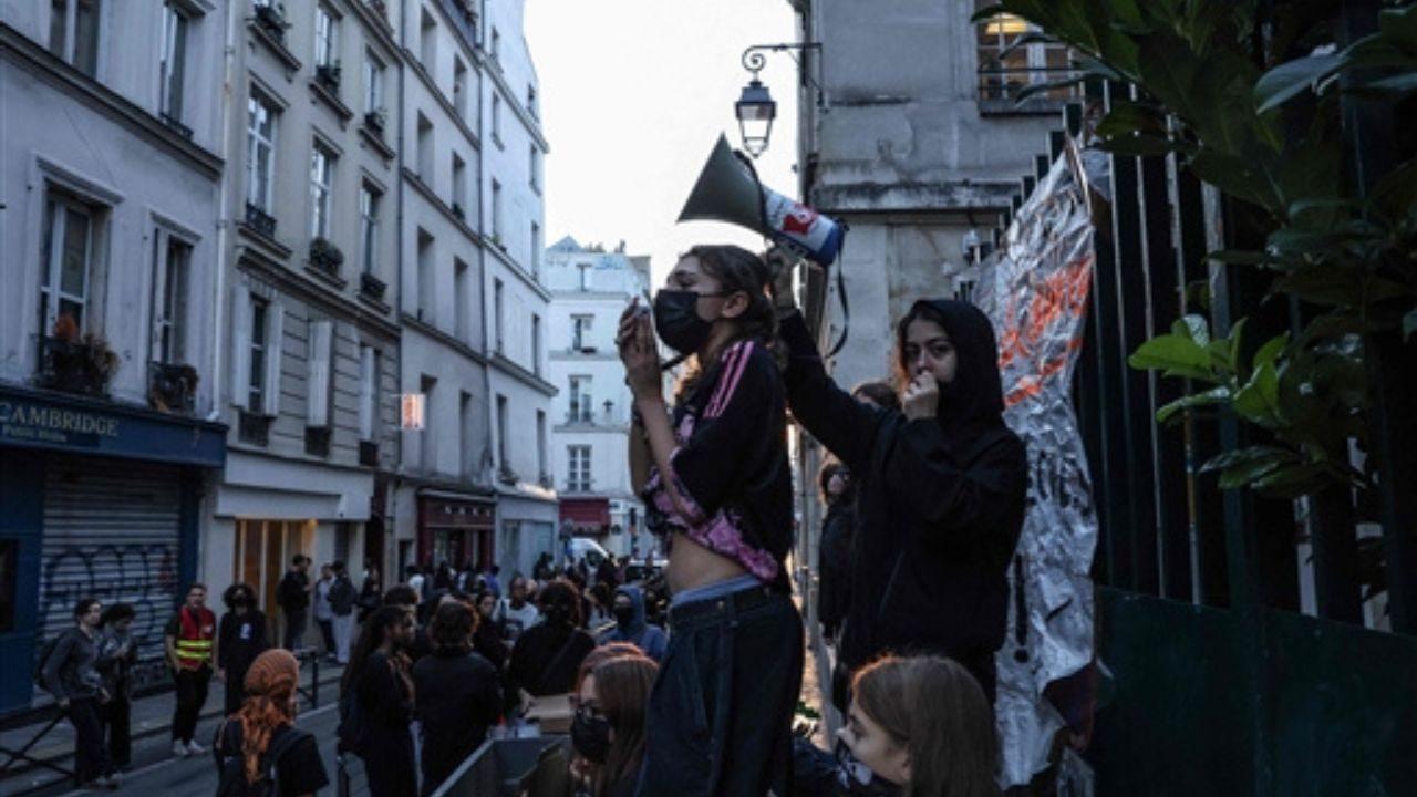 A protester uses a megaphone as students carry out a blocking protest at the Simone Veil secondary school