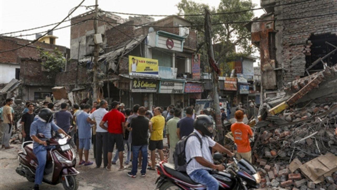 People gather at the site as a demolition drive being carried out by district administration at Nai basti area, in Jammu People gather at the site as a demolition drive being carried out by district administration at Nai basti area, in Jammu