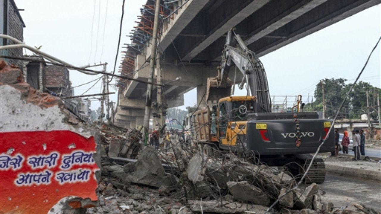 An earthmover clears debris during a demolition drive carried out by district administration at Nai Basti area, in Jammu An earthmover clears debris during a demolition drive carried out by district administration at Nai Basti area, in Jammu