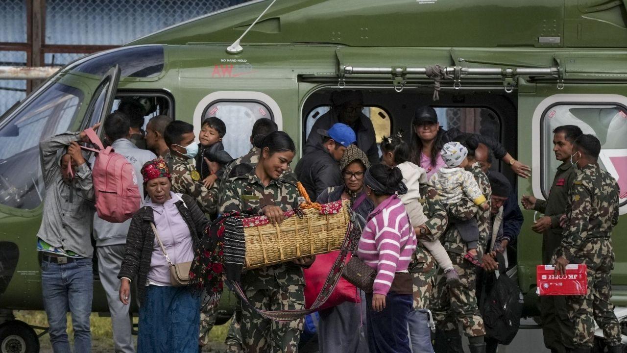 A Nepal Army official carries a baby rescued during a search and rescue operation after the devastating flash floods