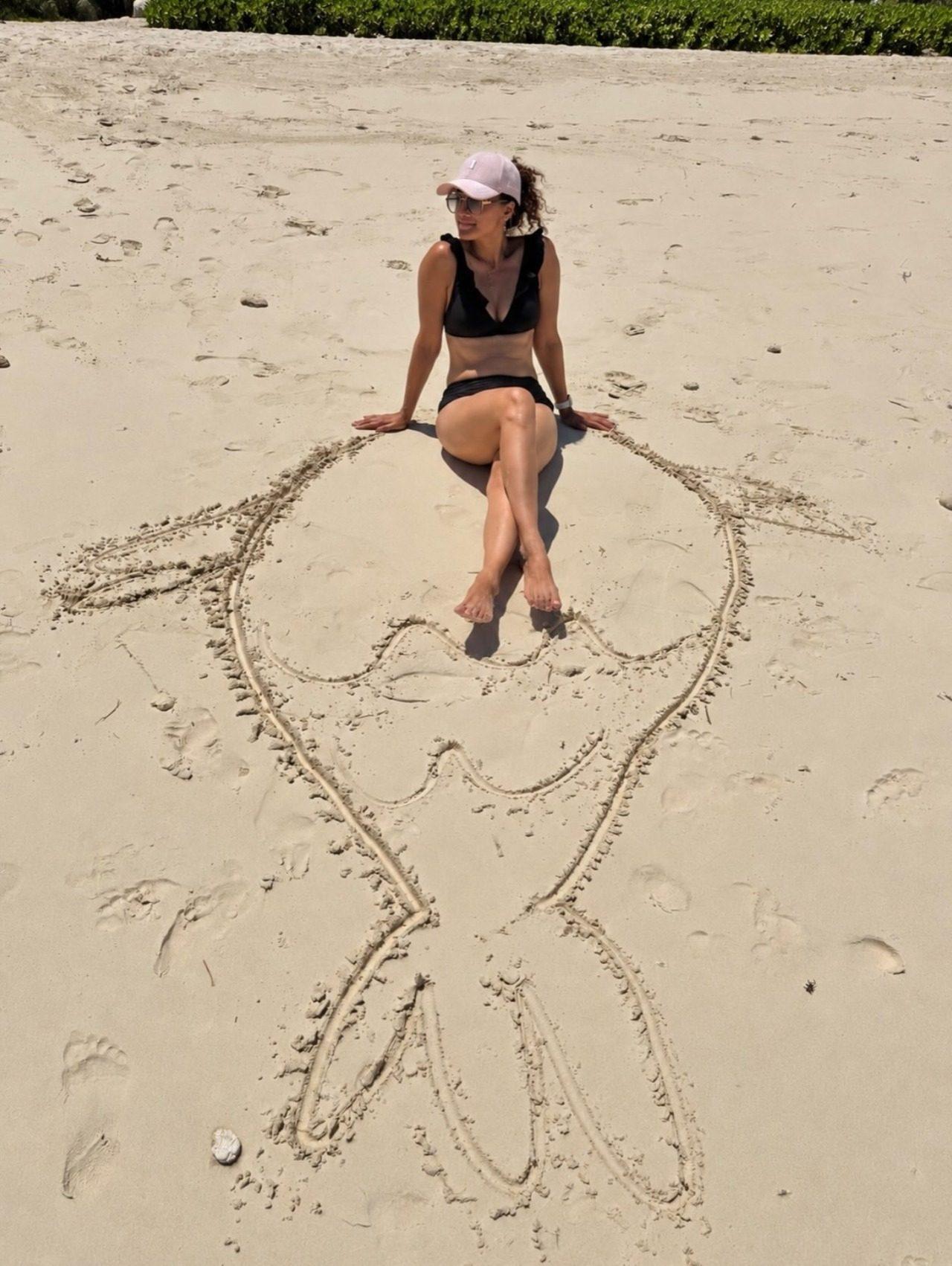 Taapsee posed while sitting on the sand with a sand drawing that forms a mermaid tail beneath her. Taapsee posed while sitting on the sand with a sand drawing that forms a mermaid tail beneath her.