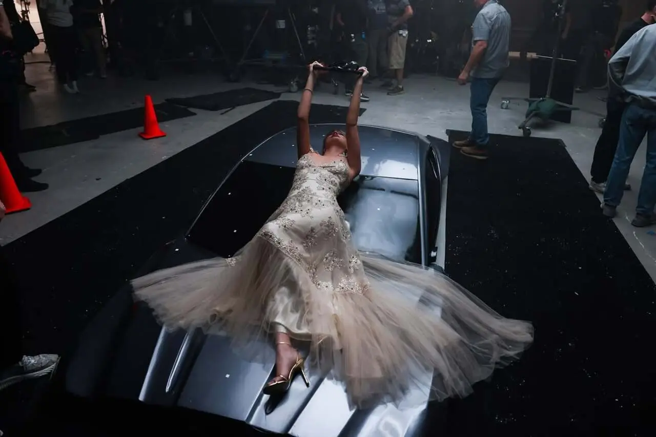 Taylor Swift give a peek into the action moments from the music video, where she lies on the car in her stunning white gown