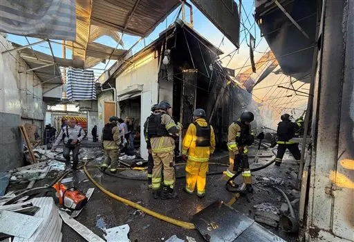 Firefighters inspect the damage at a local market following a Russian drone strike in Zaporizhzhia