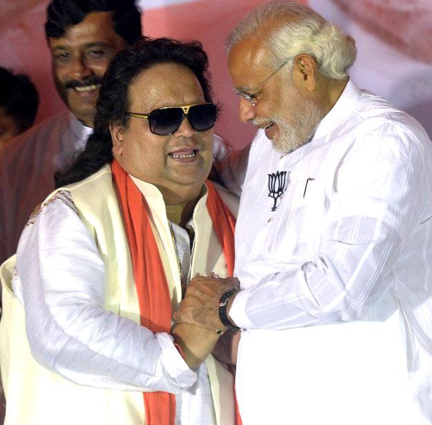 Narendra Modi greets Bollywood music composer Bappi Lahiri at an election rally in Sreerampur, around 40 km northwest of Kolkata, on April 27, 2014. Lahiri was the BJP candidate from Sreerampur parliamentary constituency during the 2014 Lok Sabha elections. Pic/AFP