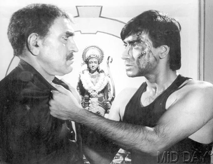 Ajay Devgn confronting Amrish Puri in a still from a film. They have worked together in several films, which include Phool Aur Kaante, Diljale, Haqeeqat, Sangram, among others.