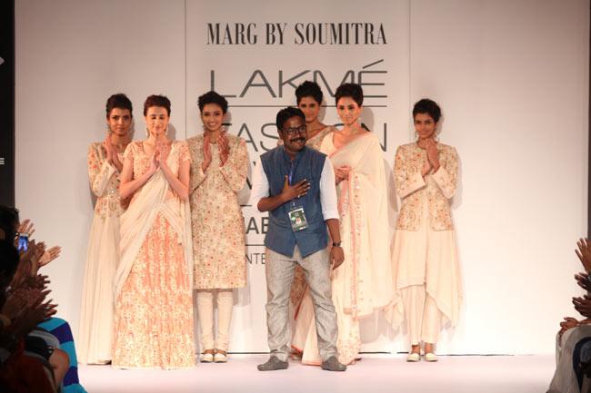 Designer Soumitra Mondal poses with some models on the runway during the showcasing of his collection 'Marg'