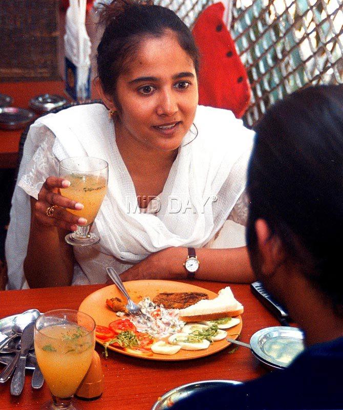 A patron enjoys a glass of Panaa, a popular mango drink at Cafe Samovar