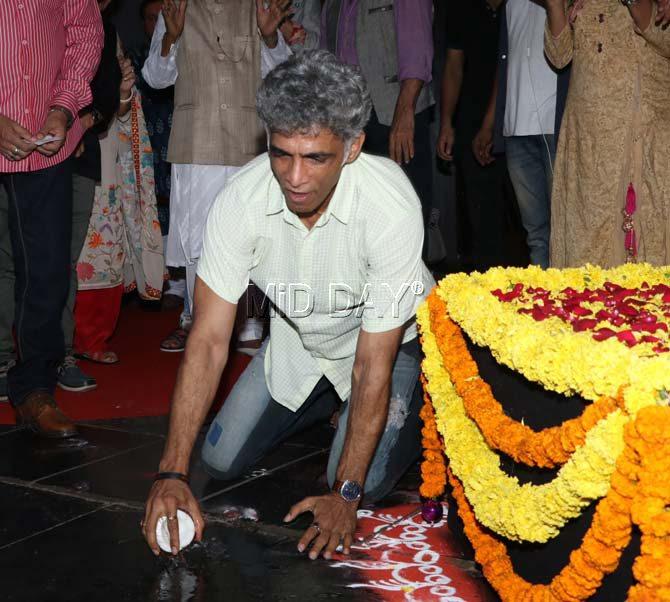 Makarand Deshpande cracks the ceremonial coconut during the inauguration of the ANSH Darshak UTSAV at Prithvi Theatre in Juhu, Mumbai