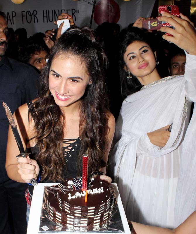 Lauren poses with her birthday cake while Mouni clicks a selfie