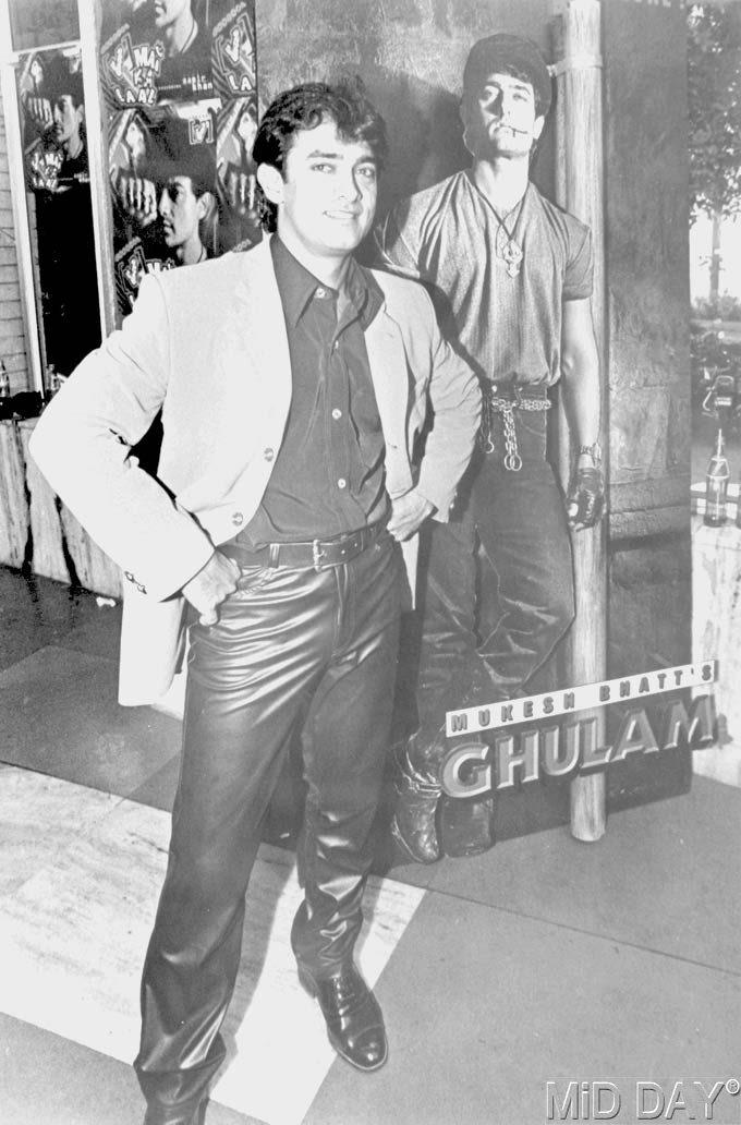 Aamir Khan strikes a pose next to the poster of Ghulam, which was a remake of the Marlon Brando classic On The Waterfront