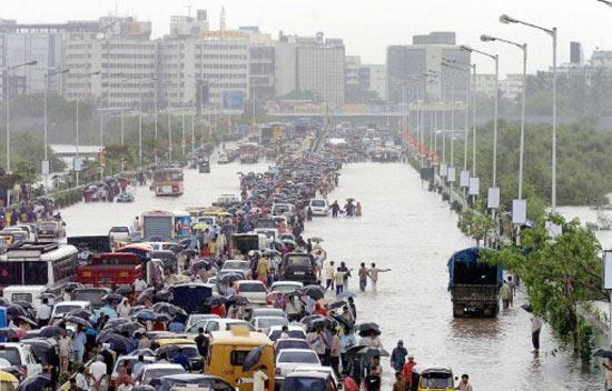 In picture: People walk on the waterlogged highway leading to Mumbai's airport during the July 26, 2005 floods.