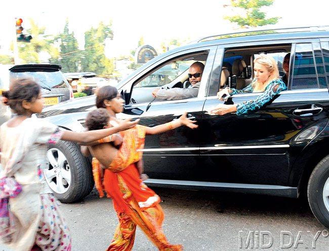 #31 September 25, 2011  PARIS IN MUMBAI: Hotel heiress gives away 100 US dollars to street children begging in Mumbai on her visit to the country. This was at Andheri. Pic/SATYAJIT DESAI