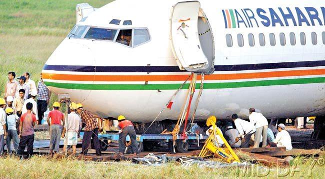 #07 October 12, 2005  NO TICKET, NO VISA: Workers are trying to tow away the Kolkata-Mumbai Sahara Airlines flight carrying 113 passengers which overshot and skidded from the runway while landing at Mumbai airport. Pic/RANE ASHISH