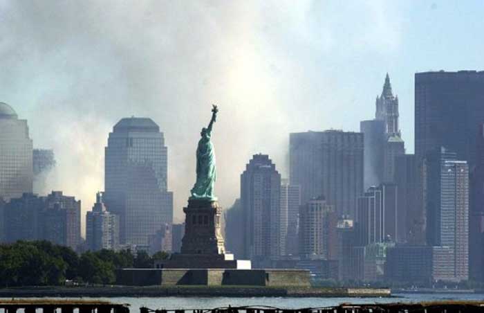 Smoke and ash from the destroyed World Trade Center rises over the southern end of New York City's Manhattan behind the Statue of Liberty as seen from Jersey City, New Jersey on September 12, 2001. Terrorists hijacked two commercial airliners and crashed them into each of the towers of the Trade Center. Pic/AFP