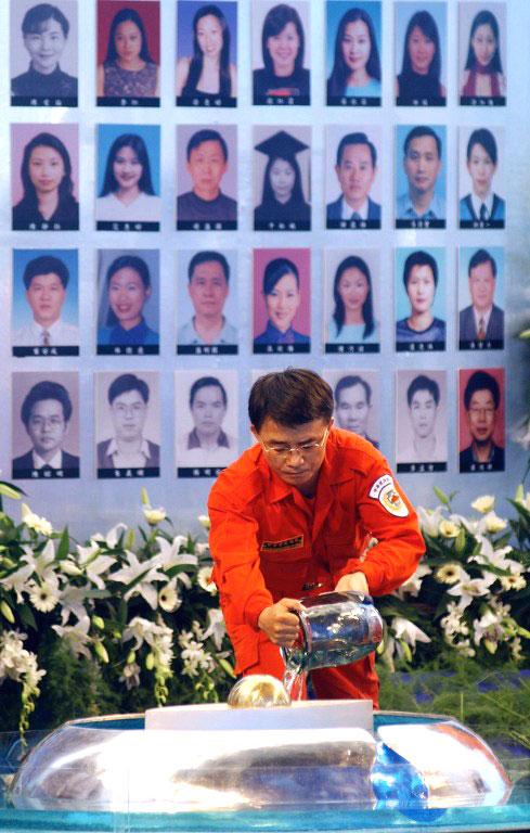 May 25, 2002: China Airlines Boeing 747 broke apart in mid-air and ploughed into Taiwan Strait. All 225 people aboard the China airlines plane were killed. In picture: A Taiwanese Coast Guard fills a container with sea water in front of portraits of the victims during a memorial service in Taipei