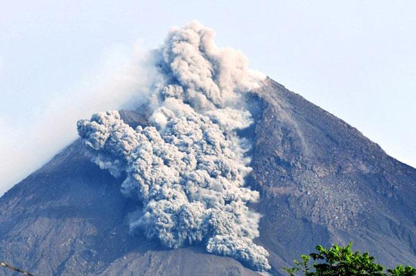 Mount Merapi volcano emits hot clouds of lava and volcanic ash as seen from Kali Tengah Lor district in Indonesia on the early morning of October 29, 2010. More than 20 of the 32 victims were buried in a mass grave in central Java as the country reeled from the twin disasters of eruption and a tsunami which struck Sumatra island, killing more than 300 people.
