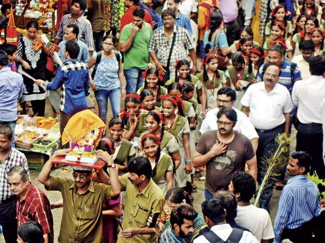 Shoppers crowd the streets, as school students follow their peon carrying the idol. Pic/Pradeep Dhivar Shoppers crowd the streets, as school students follow their peon carrying the idol. Pic/Pradeep Dhivar