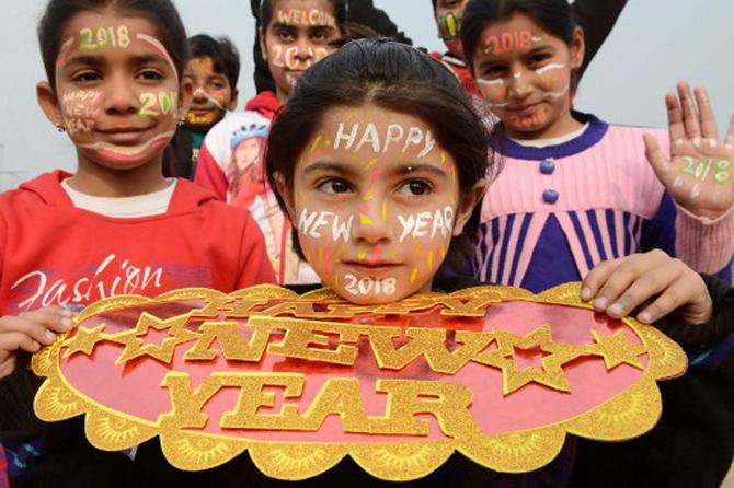 Indian children with their faces painted pose for a picture to welcome the New Year 2018 in Amritsar