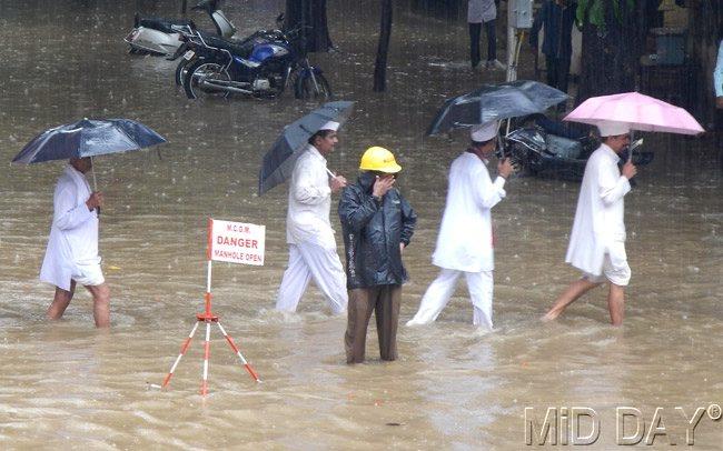 People wade through a flooded street in Parel, Mumbai. Pic/Suresh K.K.