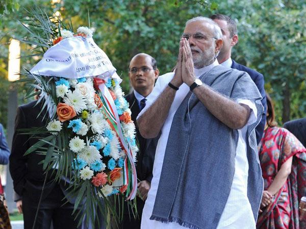 In this photograph released by the Indian Press Information Bureau (PIB), Indian Prime Minister Narendra Modi (2nd R) pays homage before placing a wreath at the 9/11 Memorial in New York on September 27, 2014 