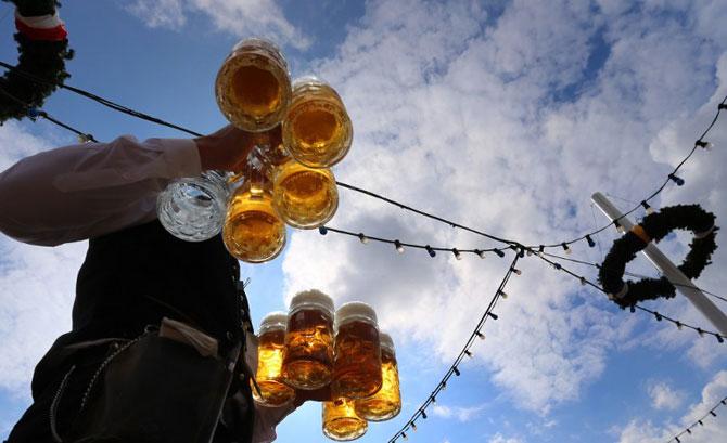A waiter carries beers at the Theresienwiese fair grounds of the Oktoberfest beer festival in Munich, southern Germany, on September 20, 2015. The World's biggest beer festival Oktoberfest started on September 19, 2015 and will take place until October 4, 2015. 
