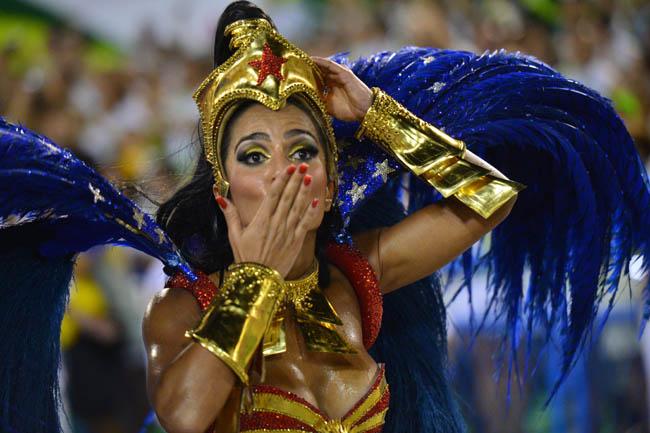 A reveler of the Uniao da Ilha samba school blows a flying kiss during the second night of carnival parade at the Sambadrome in Rio de Janeiro, Brazil  