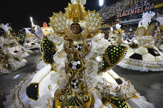 A reveler of the Imperatriz samba school performs wearing a traditional outfit during the second night of carnival parade at the Sambadrome in Rio de Janeiro, Brazil