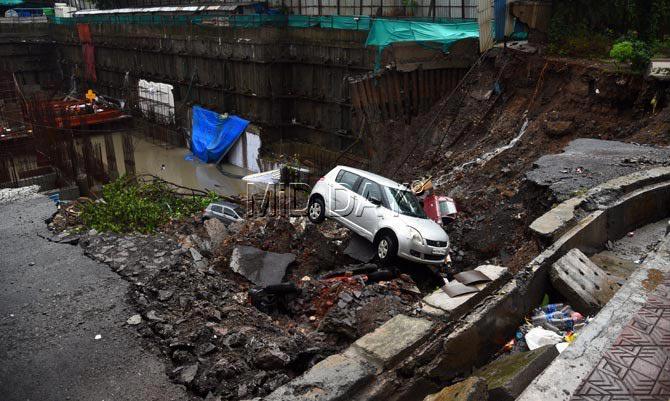 A major portion of the wall of a building compound wall of Loyd Estates, next to Dosti acres at Antop Hill collapsed on Monday morning. After the wall came down it took along 12 parked cars leaving 5 more cars, hanging off the edge. The BMC and fire department has vacated the entire C wing, which houses senior lawyers, judges and businessmen. PIC/ SHADAB KHAN