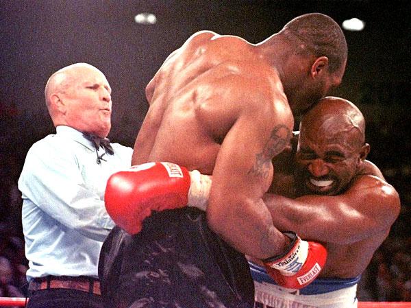 This June 28, 1997 file photo shows referee Lane Mills (L) stepping in as Evander Holyfield (R) reacts after Mike Tyson (C) bit his ear in the third round of their WBA Heavyweight Championship Fight at the MGM Grand Garden Arena in Las Vegas, NV
