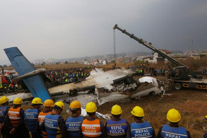 Nepalese rescuers and police are seen near the debris after a passenger plane from Bangladesh crashed at the airport in Kathmandu, Nepal, on March 12, 2018. Pic/AFP