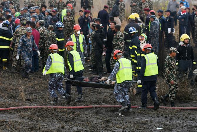Nepali rescue workers were seen removing a body found in the wreckage of the US-Bangla Airlines plane that crashed near the international airport. Pic/AFP