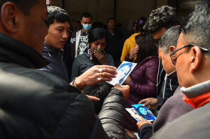 Family members hold pictures of their loved ones outside a morgue at the Teaching Hospital in Kathmandu. Pic/AFP