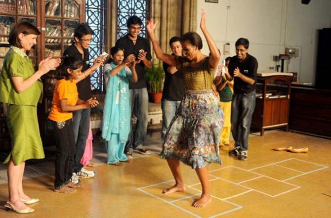 US First Lady Mitchelle Obama plays 'hopscotch' during an interaction with students from the Make A Difference (MAD) NGO, at the Mumbai University campus in Mumbai on November 6, 2010. Pic/AFP