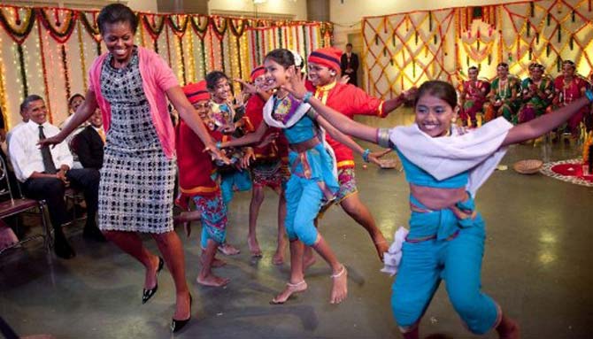 US President Barack Obama (L) watches First Lady Michelle Obama dances with children. Pic/AFP