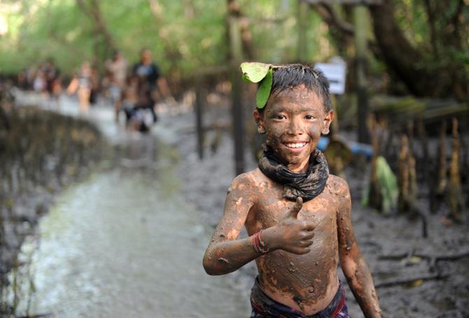 A Balinese boy puts mud on his body during a traditional mud baths known as Mebuug-buugan, in Kedonganan village, near Denpasar on Indonesia's resort island of Bali on March 18, 2018