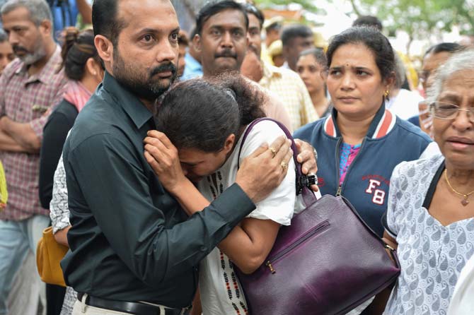 Indian journalist Gauri Lankesh's sister Kavitha Lankesh (C) is consoled by a relative as her body to brought to the Ravindra Kalakshetra cultural centre in Bangalore