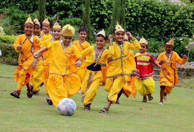 Children dressed as Lord Krishna participate in a football match during the Janmashtami celebration at a school in Patiala. Pic/PTI