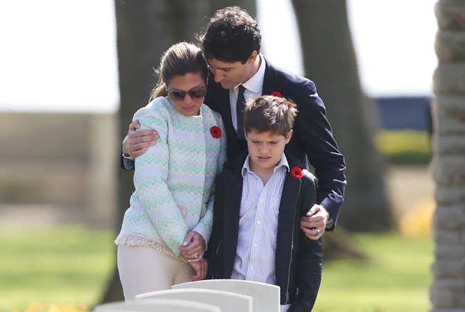 Canadian Prime Minister Justin Trudeau, his wife Sophie Gregoire and their son Xavier stand in front of the headstone of a member of Mrs Trudeau's family, who was killed during World War I, as they visit the Canadian Military Cemetery of Beny-sur-Mer, northwestern France on April 10, 2017.  All pics/AFP