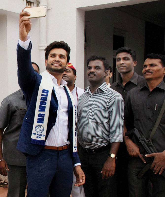 Mr World 2016 Rohit Khandelwal takes a selfie with Raj Bhavan security personnel at the Raj Bhavan in Mumbai