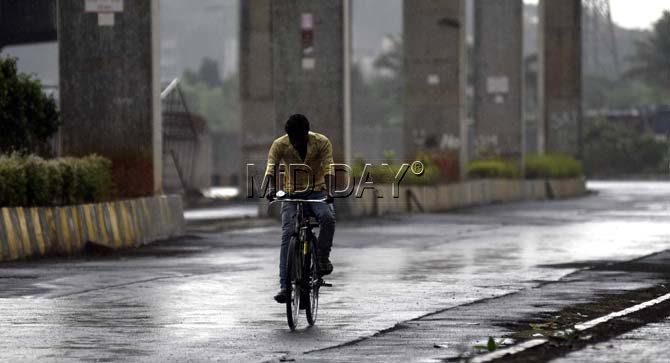A cyclist rides through a wet street in Wadala. Pic/Atul Kamble