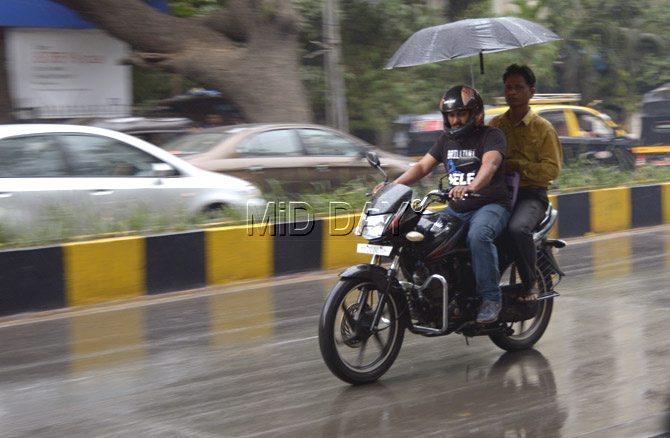 Bike-borne commuters riding on a rain-washed street in Khar. Pic/Pradeep Dhivar