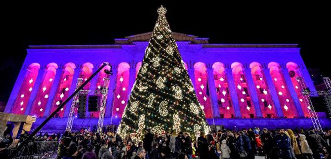 People walk past a Christmas tree illuminated in Georgia's central Tbilisi