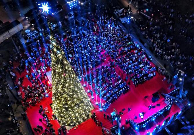 People take photos of fireworks during an event to turn on the lights of a Christmas tree in downtown Beirut, early in December